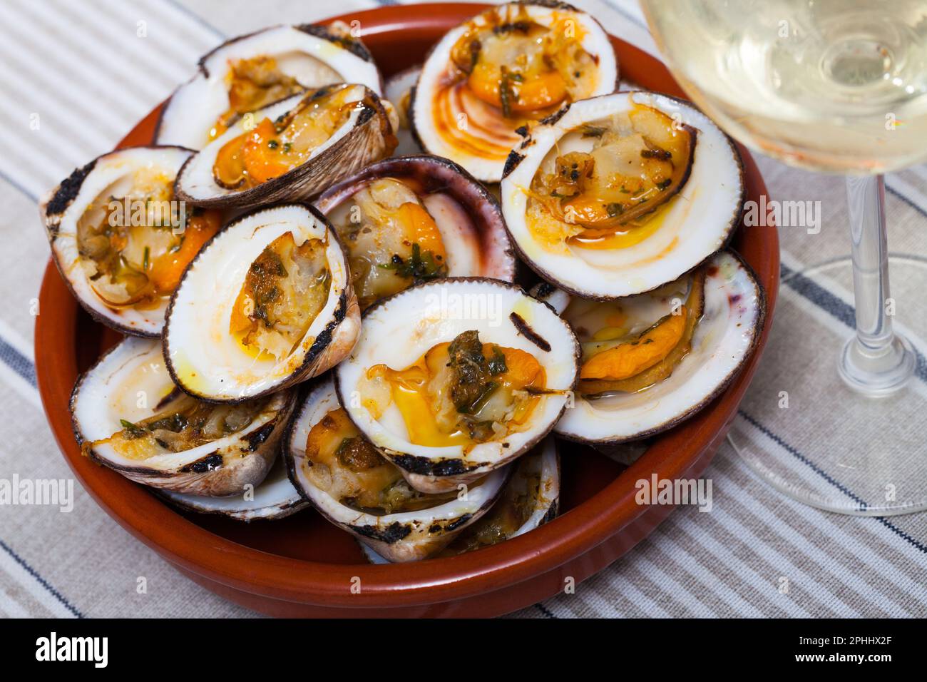 Gebacken im Ofen mit Sauce offene Muschel serviert auf weißem Teller Stockfoto