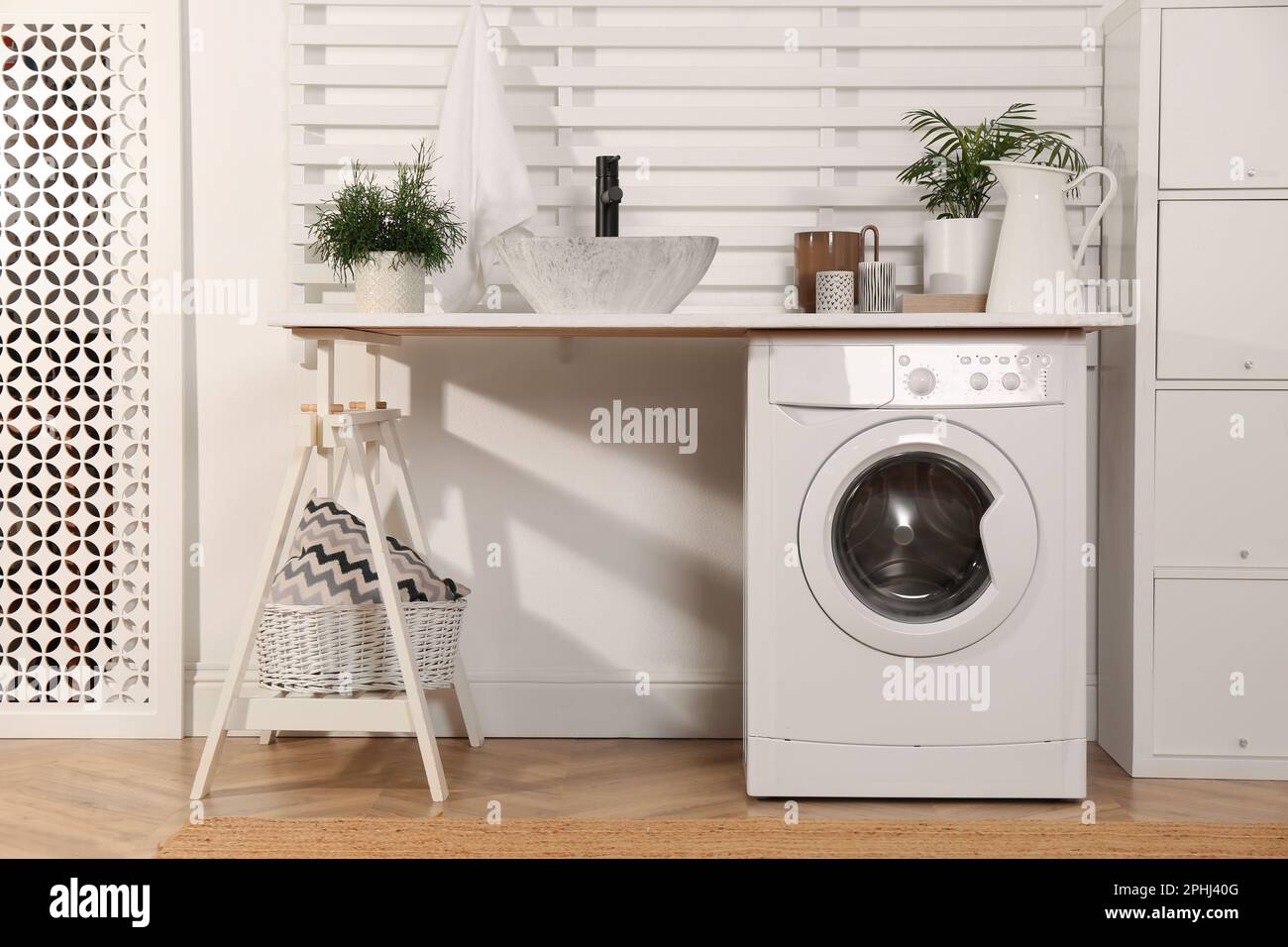 Waschraum mit moderner Waschmaschine und Regal in der Nähe der weißen Wand  Stockfotografie - Alamy