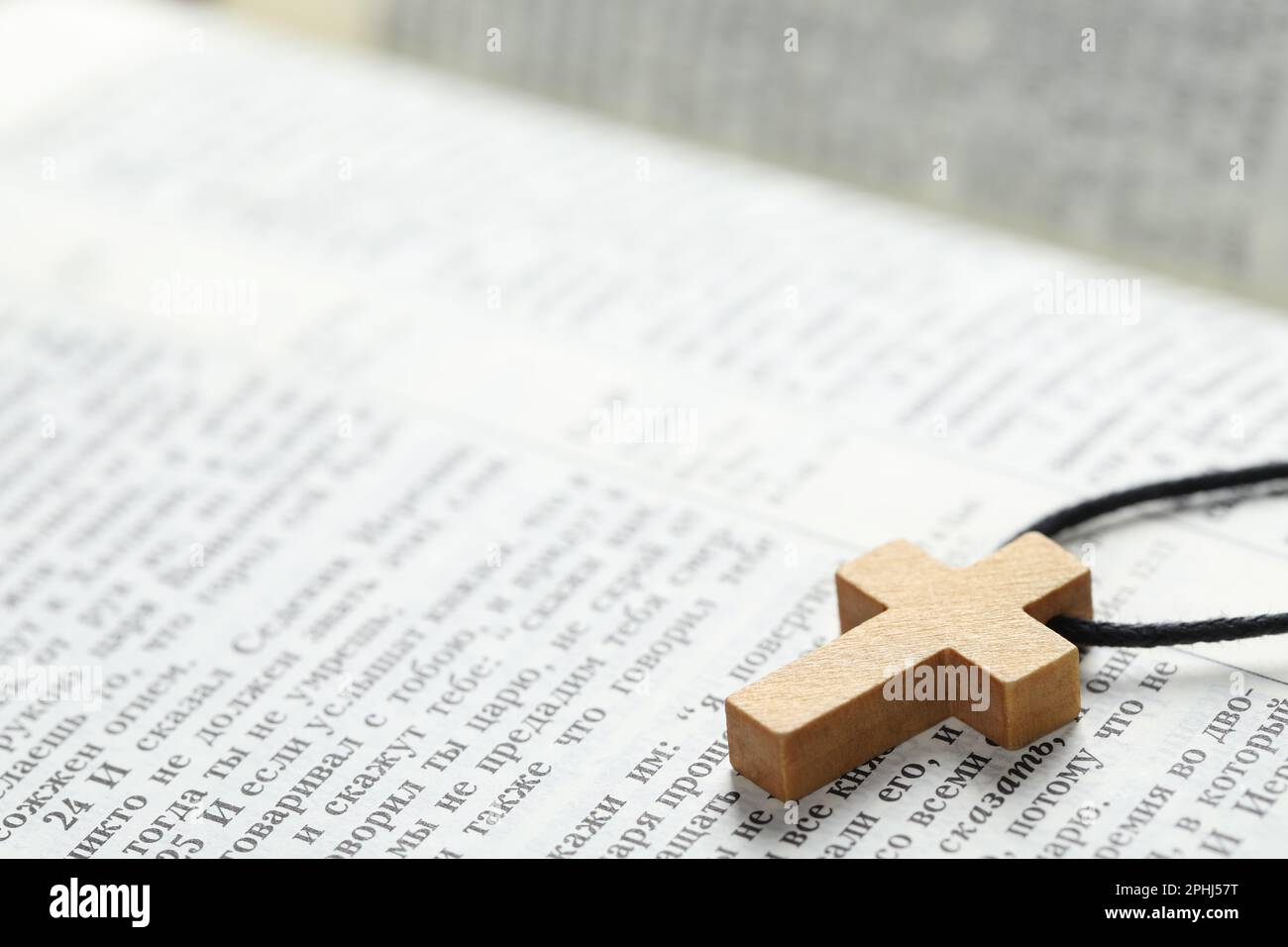 MYKOLAIV, UKRAINE - 21. DEZEMBER 2021: Holzkreuz auf der Bibel, Nahaufnahme. Text auf russisch Stockfoto