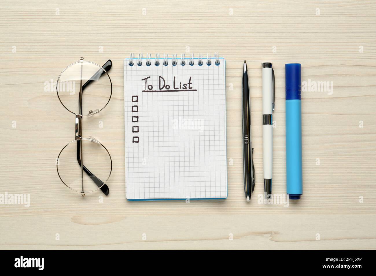 Notizblock mit ungefüllter To-do-Liste, Schreibwaren und Gläser auf Holztisch, flach liegend Stockfoto