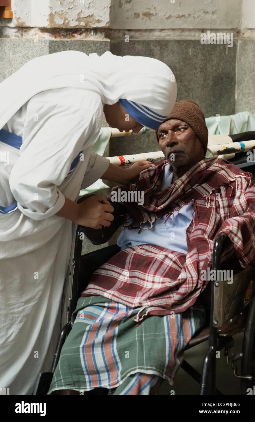 Mutter Teresa Schwester tröstet einen Patienten im Heim für die Sterbenden in Kalkutta, Indien Stockfoto