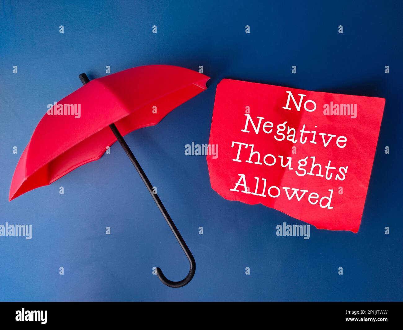 Roter Regenschirm und rotes Notizbuch mit Text Keine negativen Gedanken erlaubt. Das Busenkonzept. Stockfoto