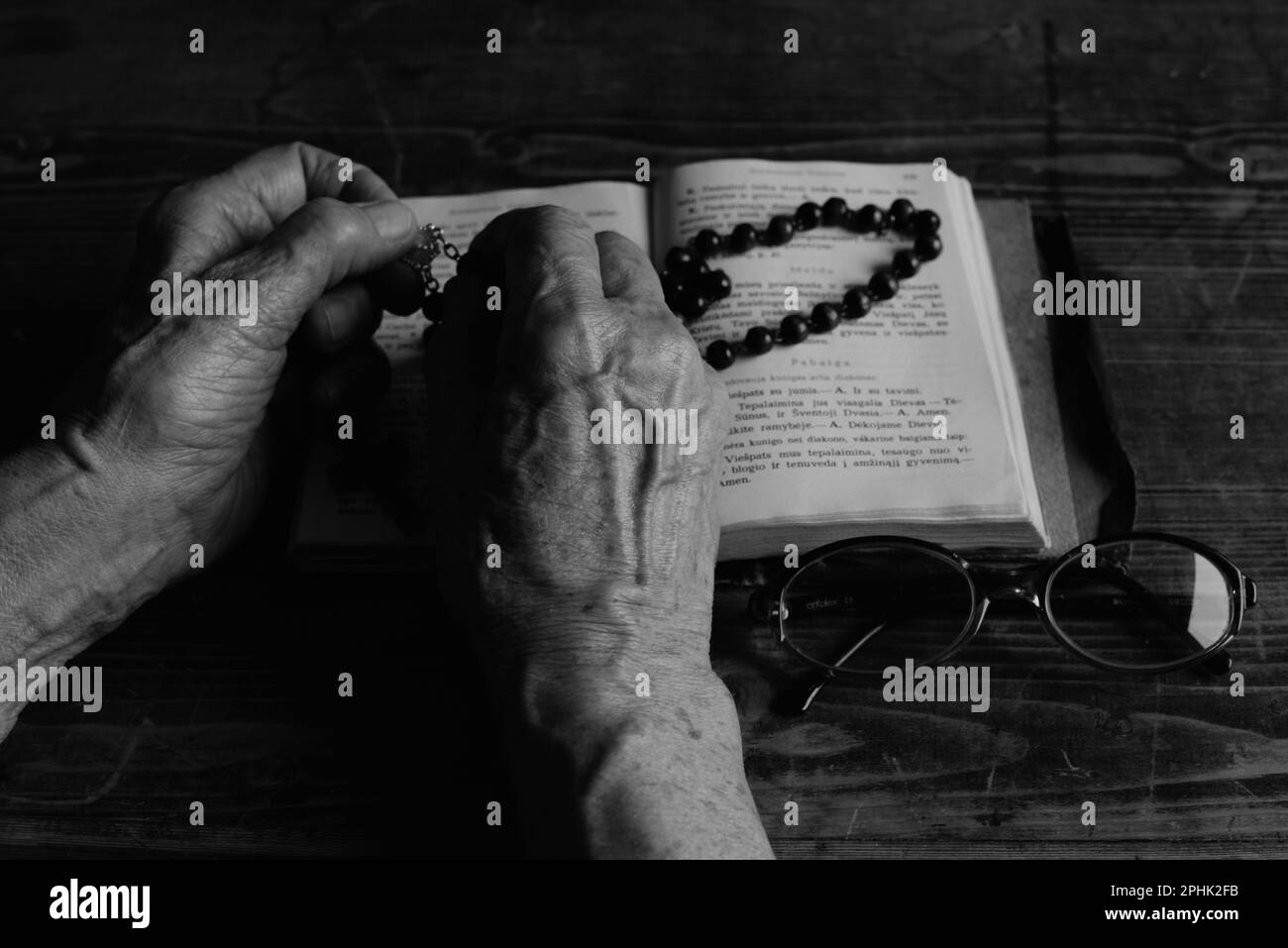 Großmutterhände, bibel, Brille, Rosenkranz Stockfoto