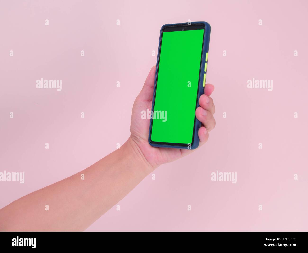 Mobiles Smartphone mit menschlicher Hand und grünem Bildschirm in vertikaler Position isoliert auf pinkfarbenem Hintergrund. Beschneidungspfad Stockfoto