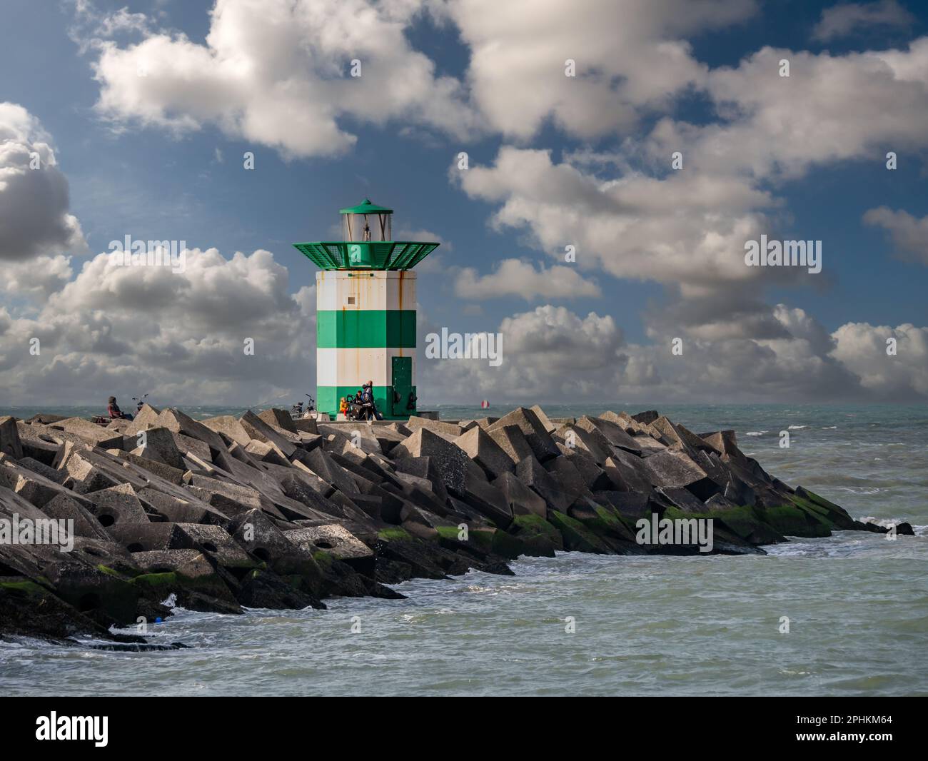 Südlicher Pier mit grünem weißem Leuchtturm am Eingang zum Hafen von Scheveningen, Den Haag, Niederlande Stockfoto
