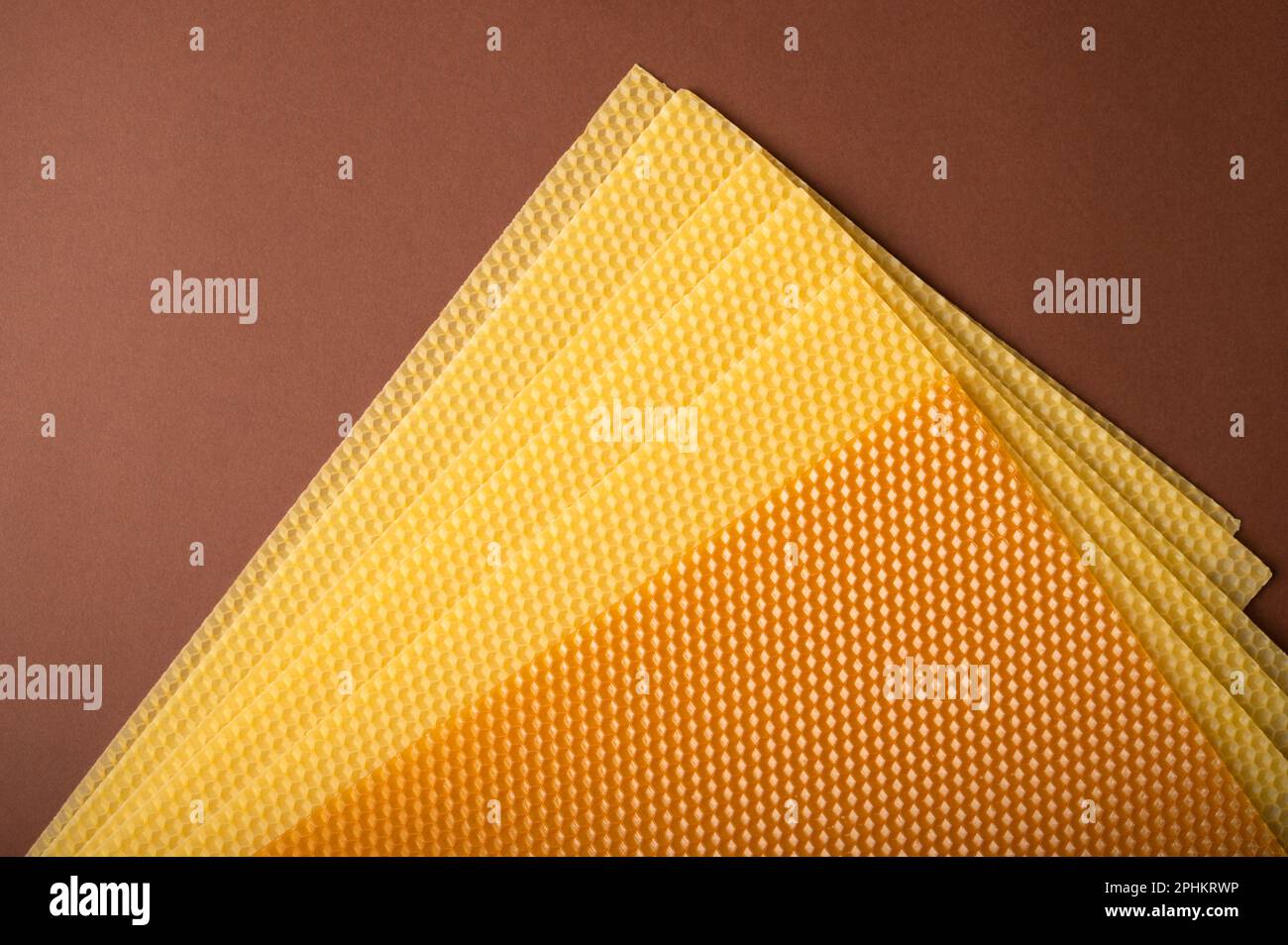 Bienenwachs-Honigwaben-Kerzenlaken auf braunem Hintergrund. Kerze Schritt für Schritt machen Stockfoto