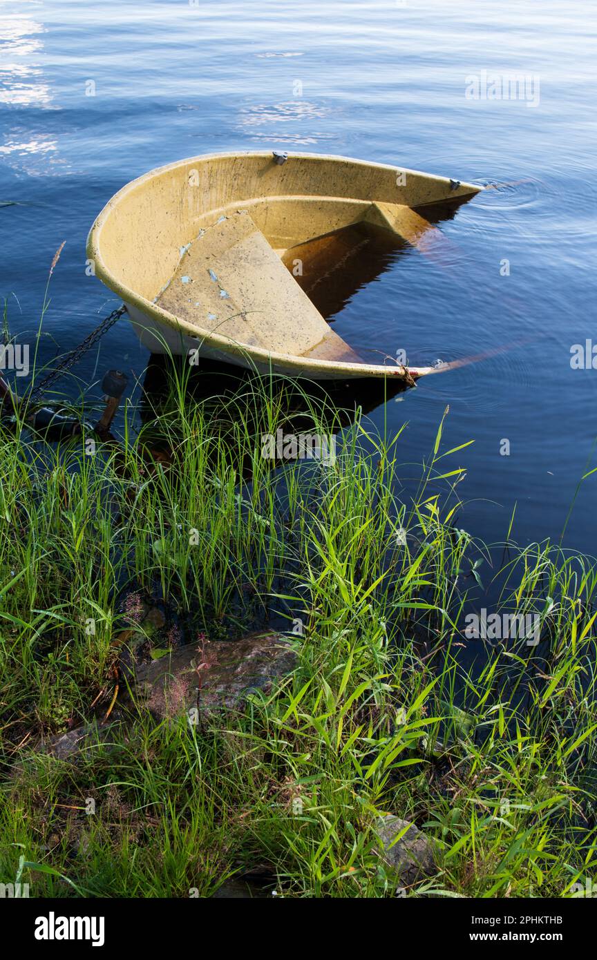 Versunkenes kleines Motorboot am Ufer Stockfoto