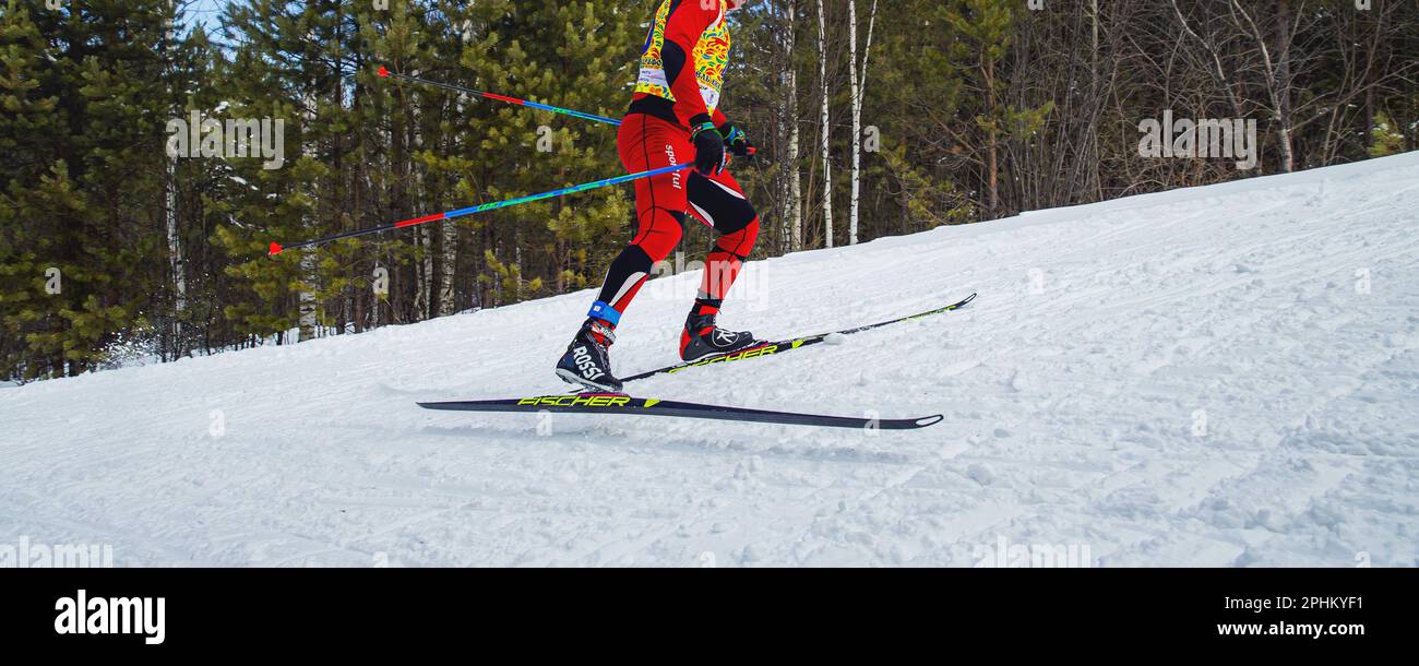 Männlicher Sportler, der beim Skilanglauf bergauf läuft, Fischer Rennskier, Rossignol Skistiefel, Skin Suit Sportful, olympische Wintersportarten Stockfoto