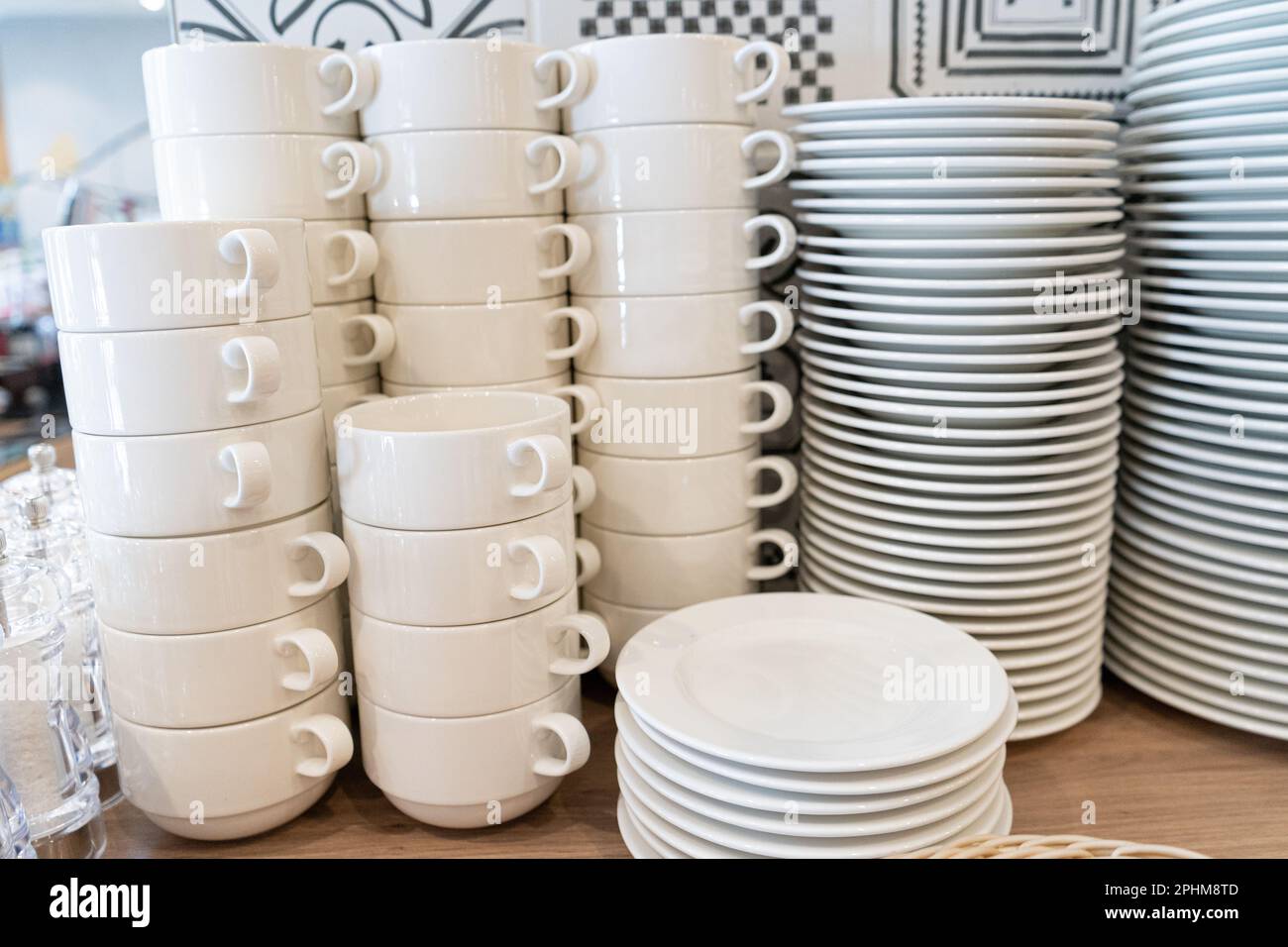 Stapel sauberer Becher, Schüsseln, Teller am Hotel Frühstücksbuffet, jede Menge weißes Geschirr Stockfoto