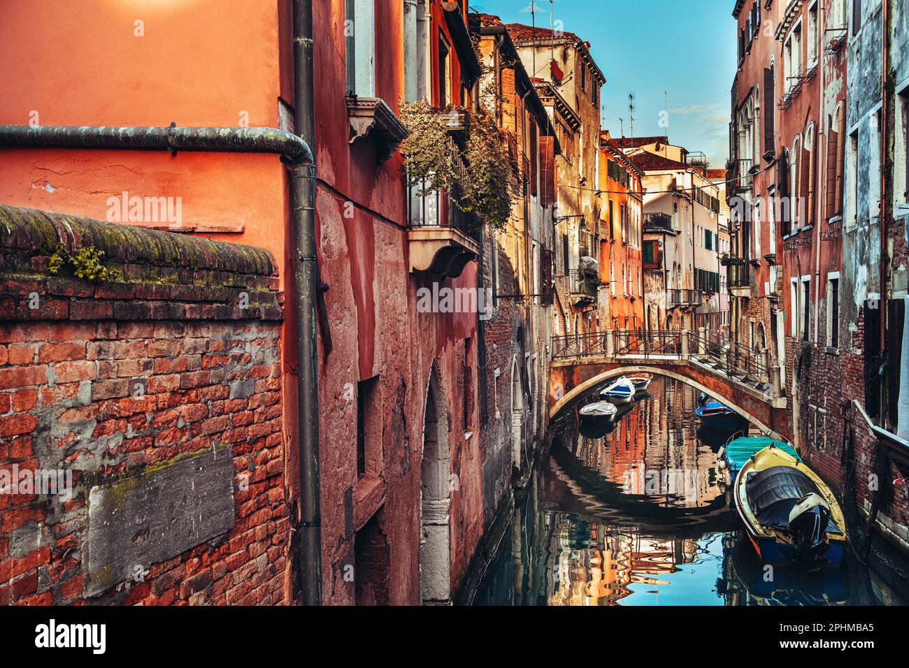 Eine idyllische Kanalszene mit einer Brücke, Gebäuden und Booten in Venedig, Italien Stockfoto