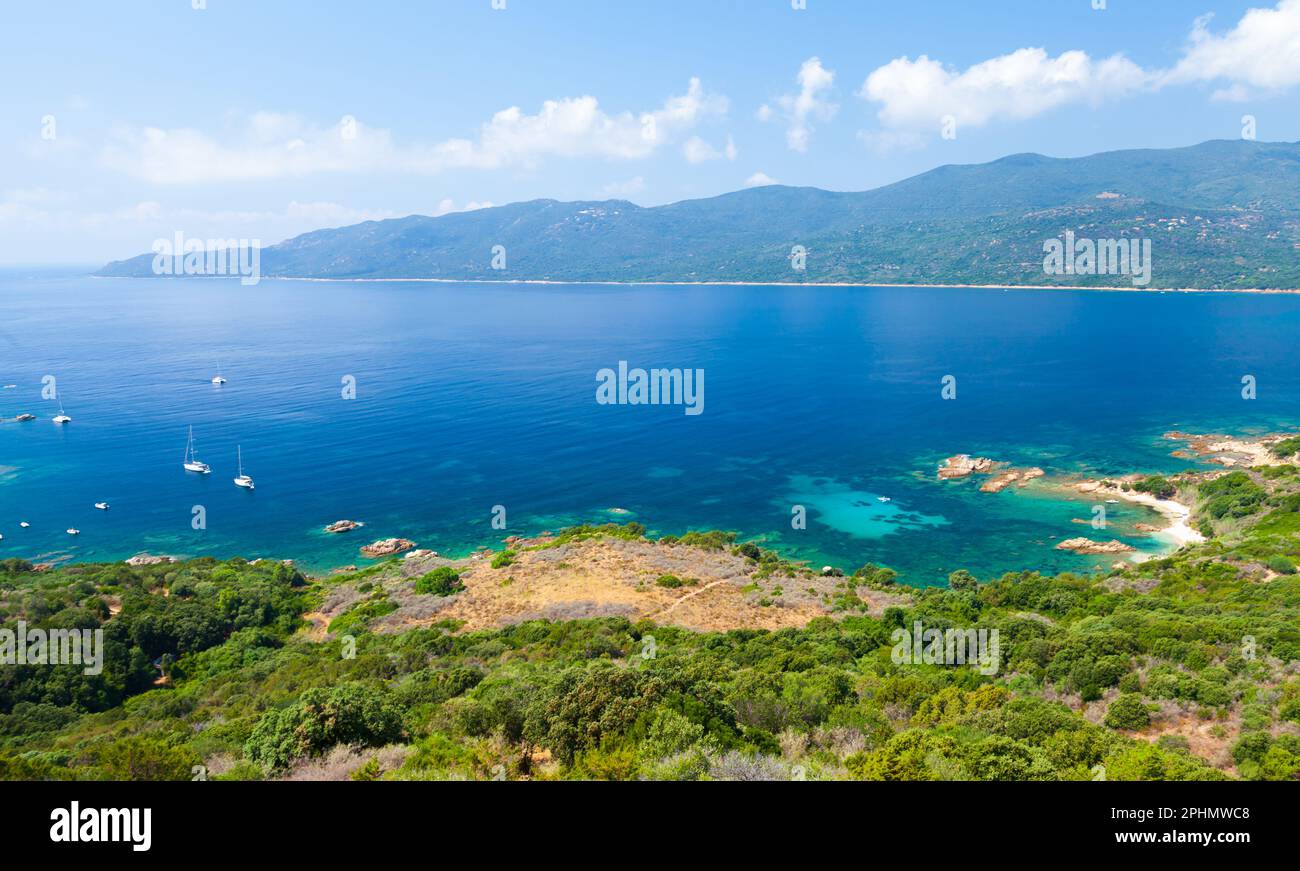 Korsika Insel an einem sonnigen Tag, Kupabia Golf. Sommerlandschaft mit Vergnügungsbooten, die in der Nähe der felsigen Küste vor Anker liegen Stockfoto