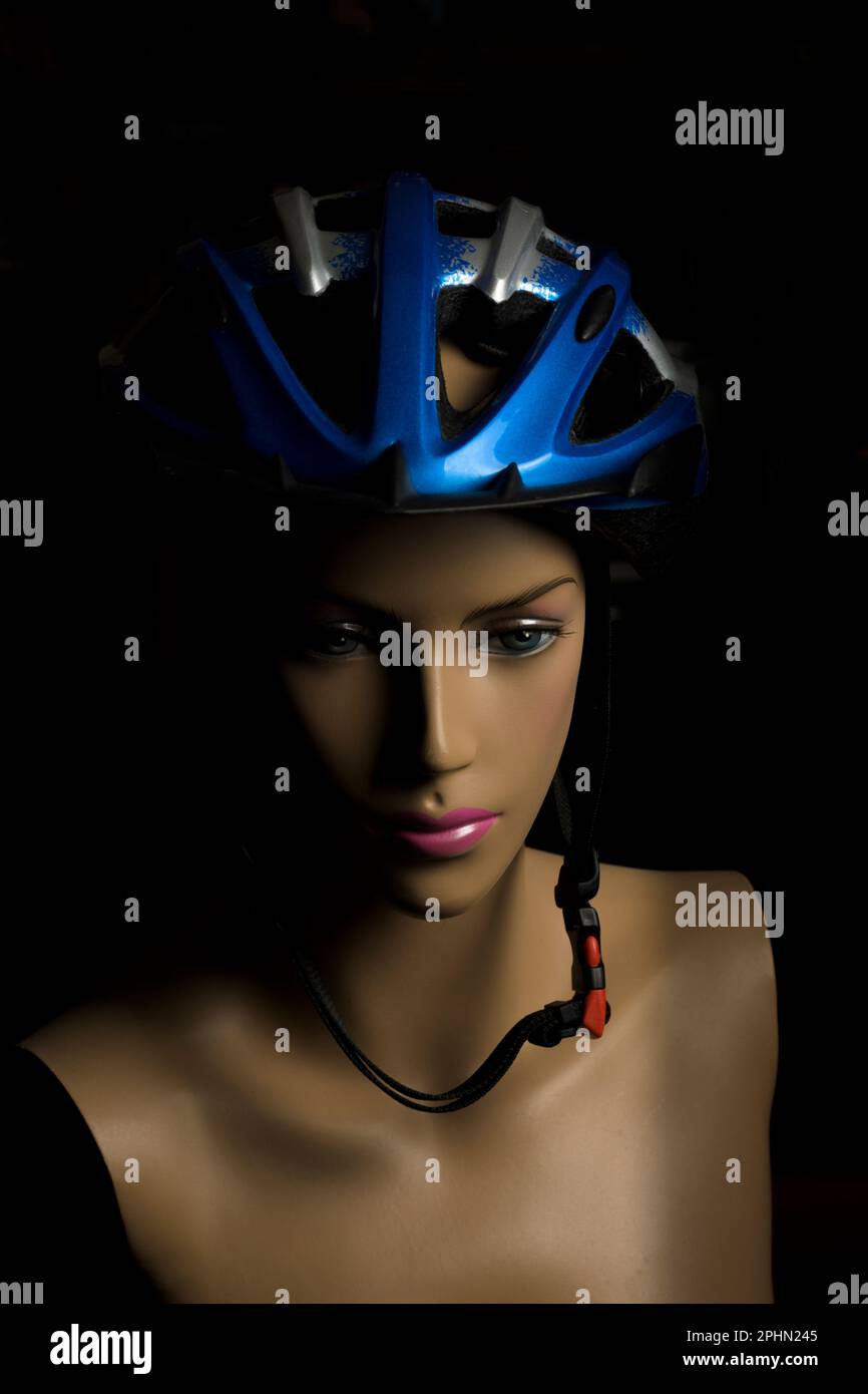 Blauer Fahrrad-Sporthelm auf einer Schaufensterpuppe mit weiblichem Gesicht zum Schutz der Puppe Stockfoto