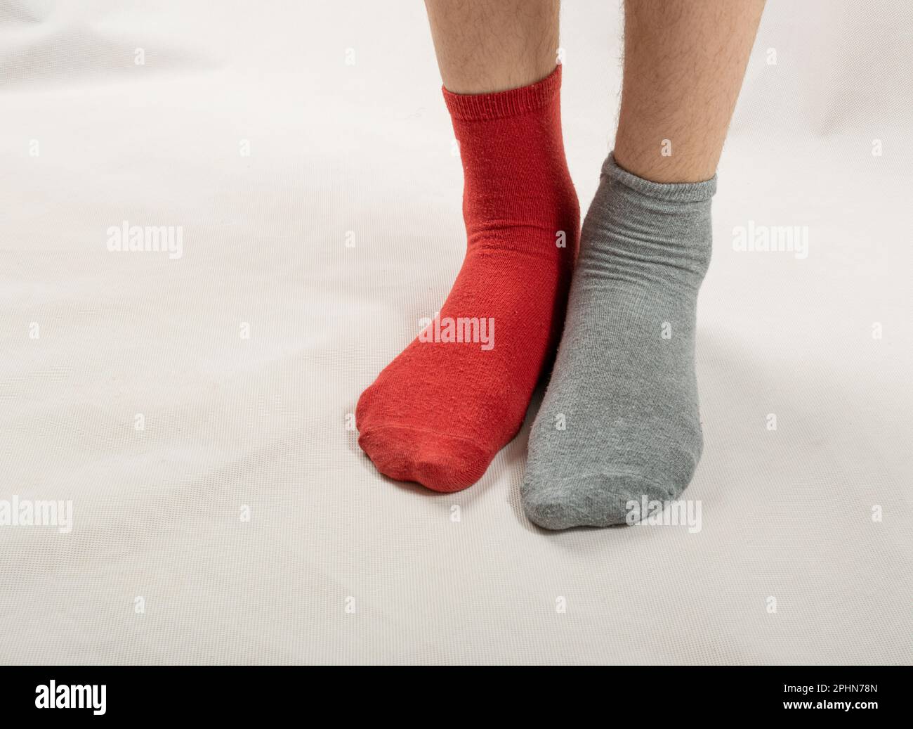 Legs in Different Socks, März 21, World Down Syndrome Day, Paar rote und graue Socken Stockfoto