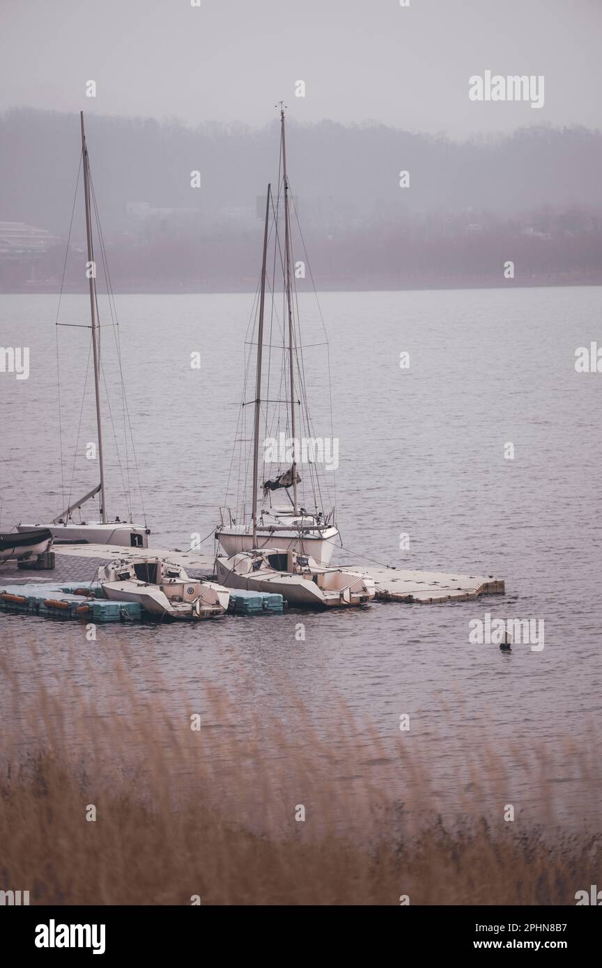 Zwei kleine Boote sind sicher an einem Dock in einem ruhigen See befestigt Stockfoto