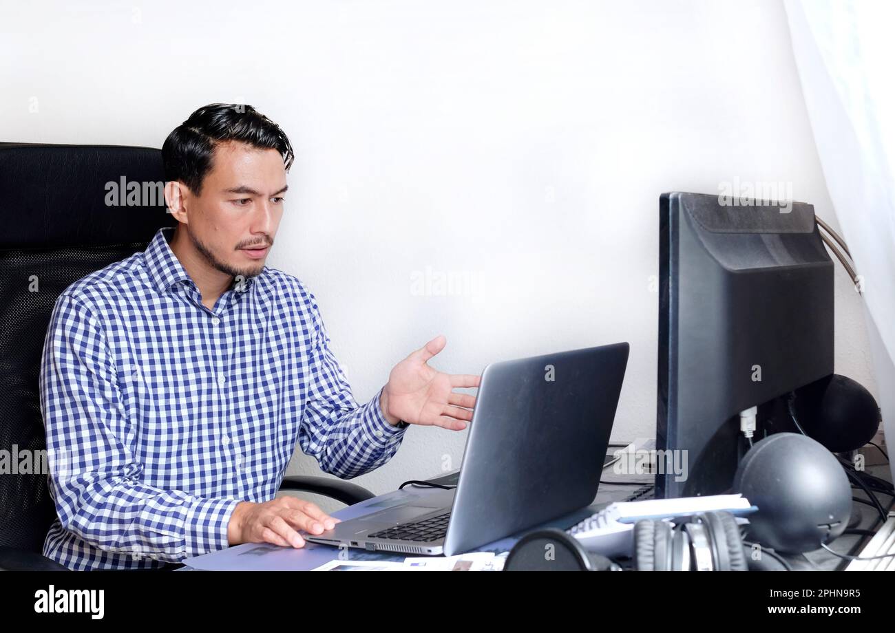 Computerprobleme - ein Mann, der auf ein Notebook blickt, ist verwirrt Stockfoto