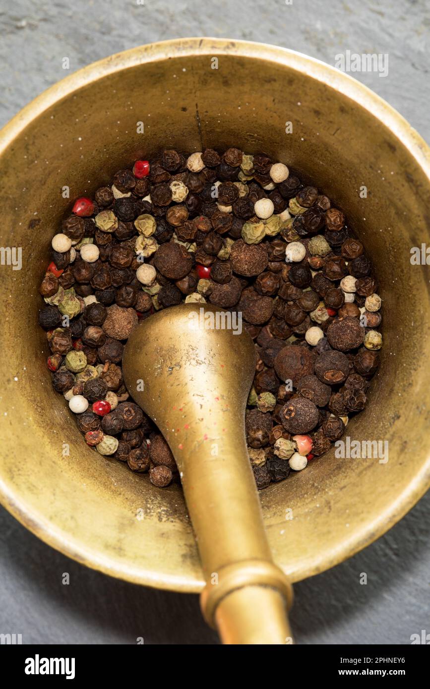 un mortaio con vari tipi di pepe colorato al suo interno Stockfoto