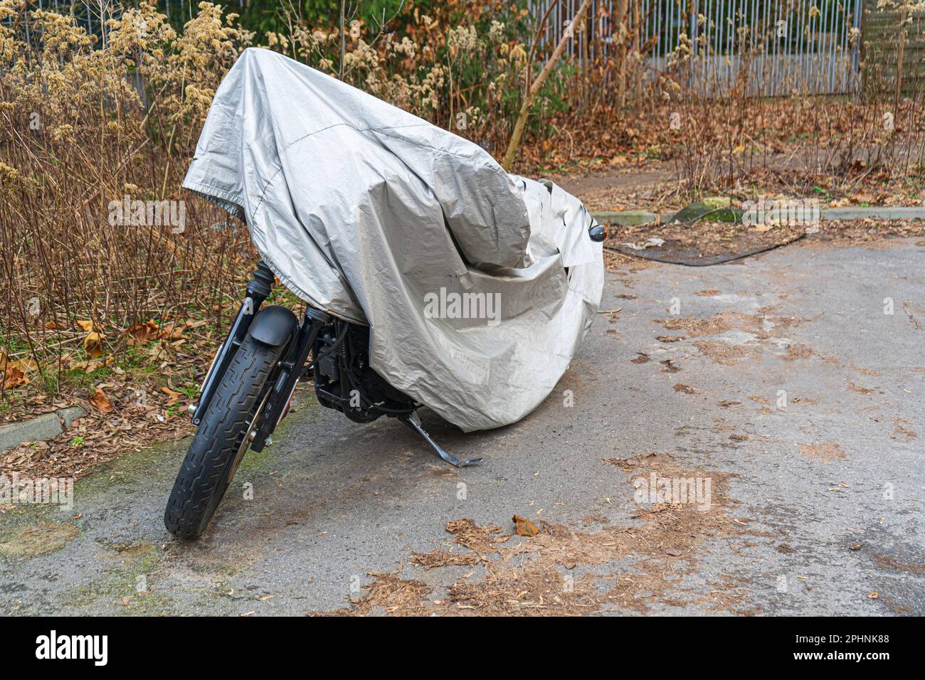 Wasserdichte Abdeckung für Motorrad, Motorrad mit Schutztuch bedeckt, Motorrad-Stoffschild auf dem Parkplatz Stockfoto