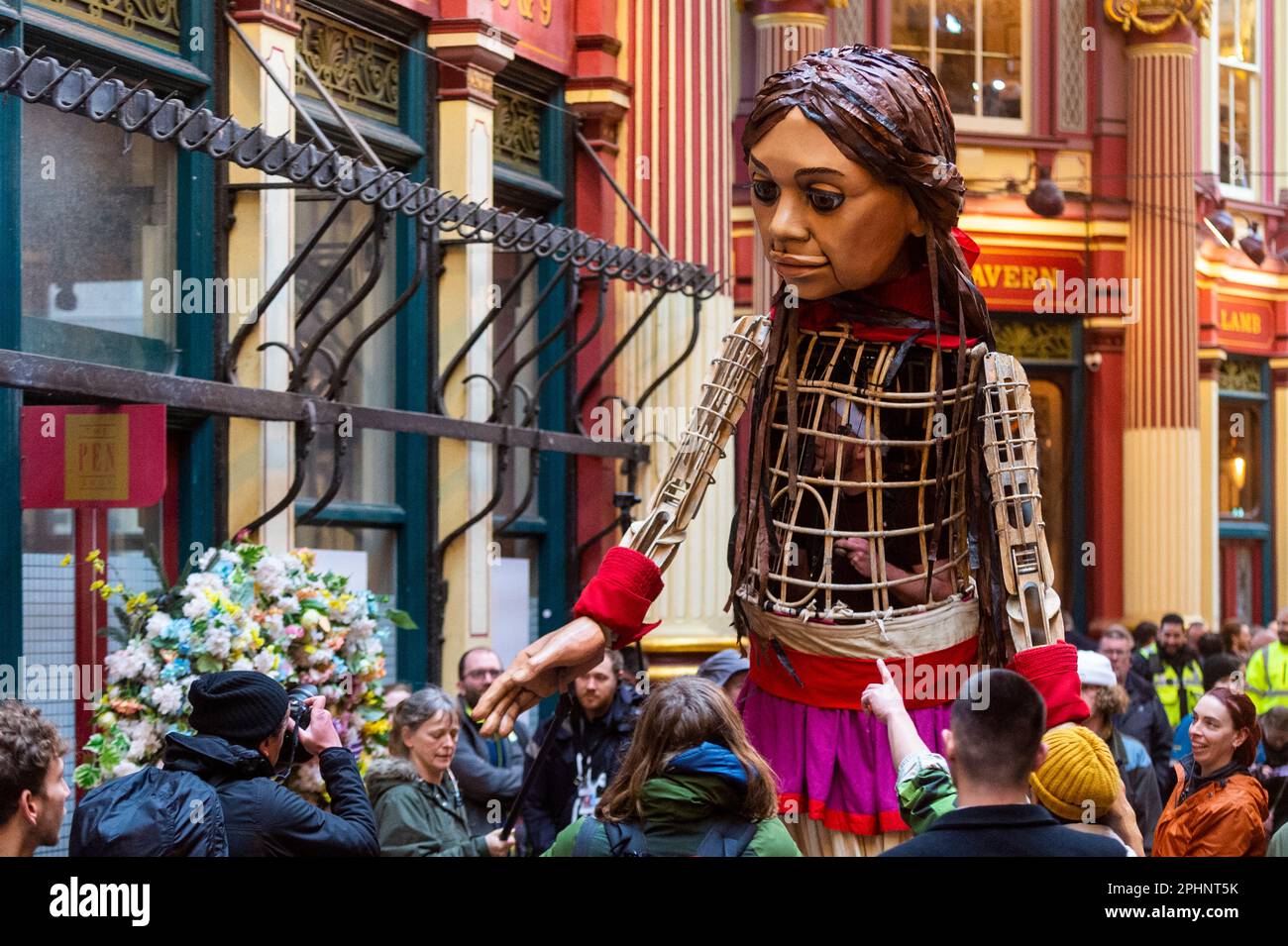 London, Großbritannien. 29. März 2023 Little Amal, eine 3,5m-jährige Marionette eines 10 Jahre alten syrischen Flüchtlingsmädchens, macht einen Spaziergang durch den Leadenhall Market in der Londoner City, um Mittel für vertriebene Kinder zu sammeln, einschließlich der Kinder, die von den jüngsten Erdbeben in der Türkei und Syrien betroffen sind. Als sie letztes Jahr an der syrischen Grenze ihre Reise begann, ist Amal zu einem weltweiten Symbol der Menschenrechte geworden, insbesondere für junge Flüchtlinge, die von ihren Familien getrennt sind. Die kleine Amal wird über das Wochenende in London und Brighton weiterspazieren. Kredit: Stephen Chung / Alamy Live News Stockfoto