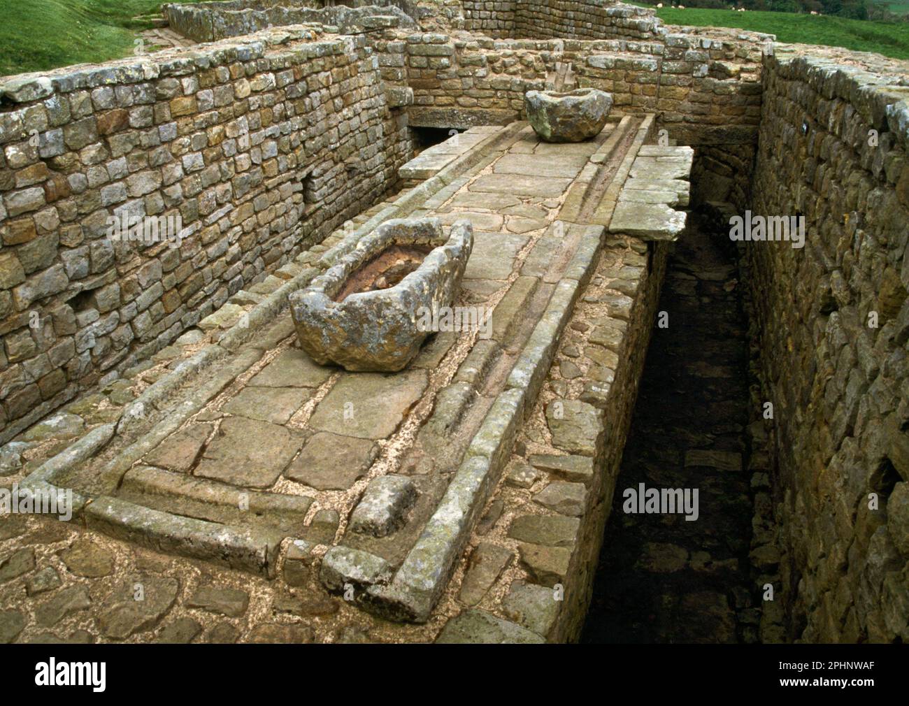 Latrinen, Wasserkanäle, Becken und Abflüsse in der südöstlichen Ecke des römischen Forts Housesteads, Hadrian's Wall, Northumberland, England, Großbritannien. Stockfoto