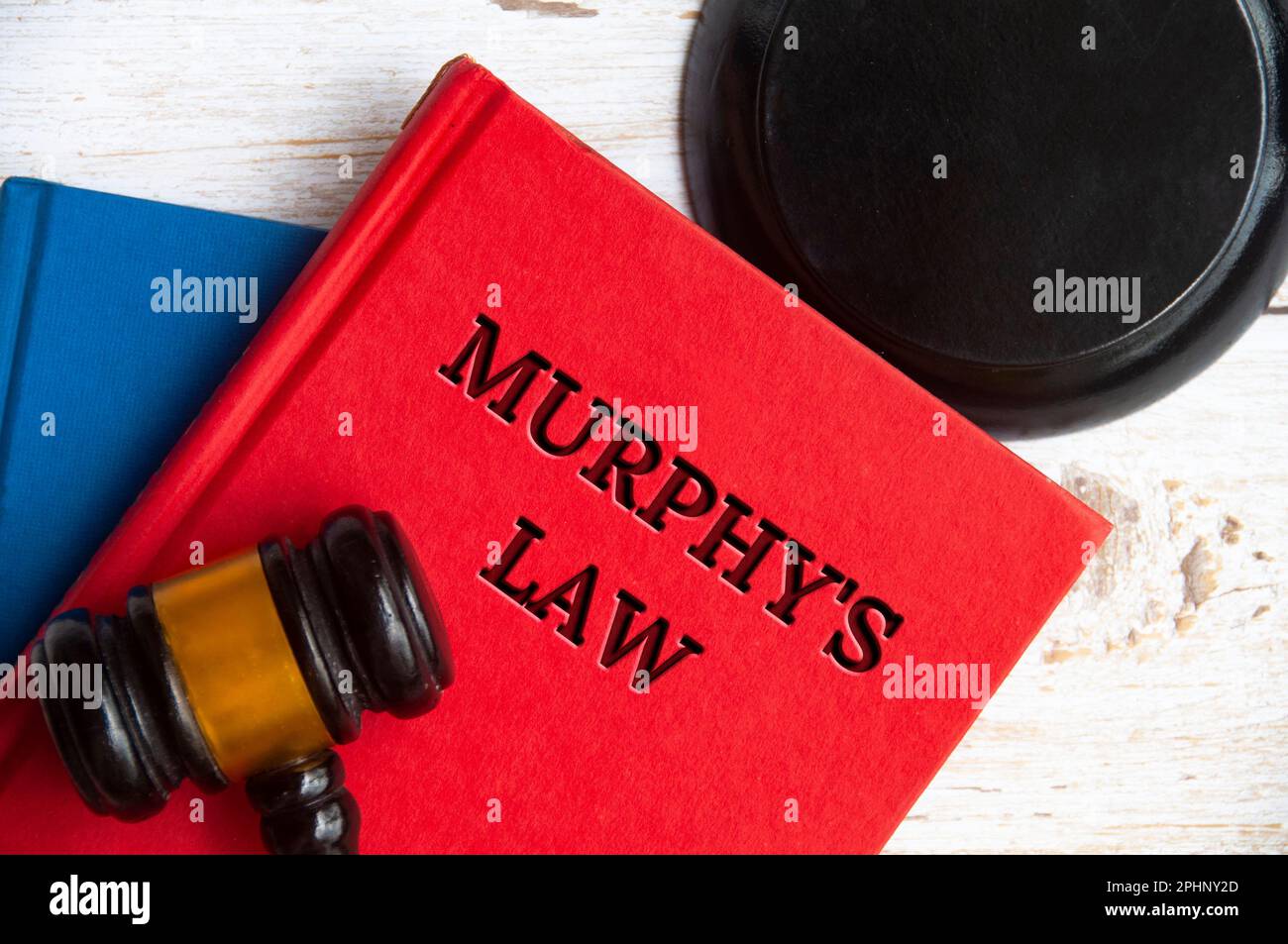 Blick von oben auf Murphys Buch des Gesetzes auf einem Holztisch mit Hammer-Hintergrund. Stockfoto