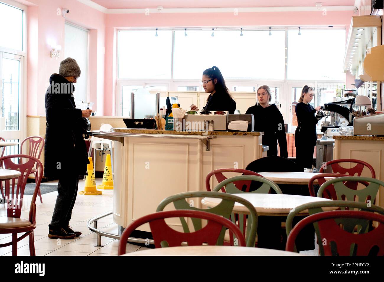 Eine Seniorin bestellt Kaffee und Kuchen an der Theke im Pacittos Temperance Café in Redcar Sea Front North Yorkshire Stockfoto