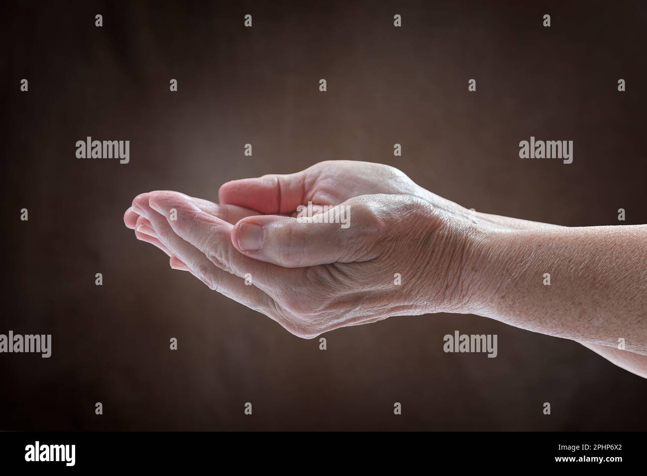 Horizontalaufnahme der bedürftigen Schrumpfhände einer älteren Frau. Stockfoto