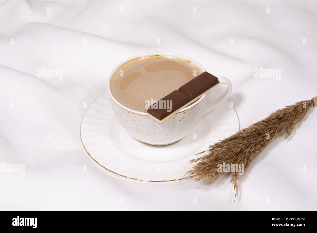 Tasse aus weißem Porzellan mit süßer dunkler Schokolade auf einem flachen weißen Kaffeegetränk in einer Tasse auf weißem ästhetischem Hintergrund, Bild-ID: 2PHP8DM Stockfoto