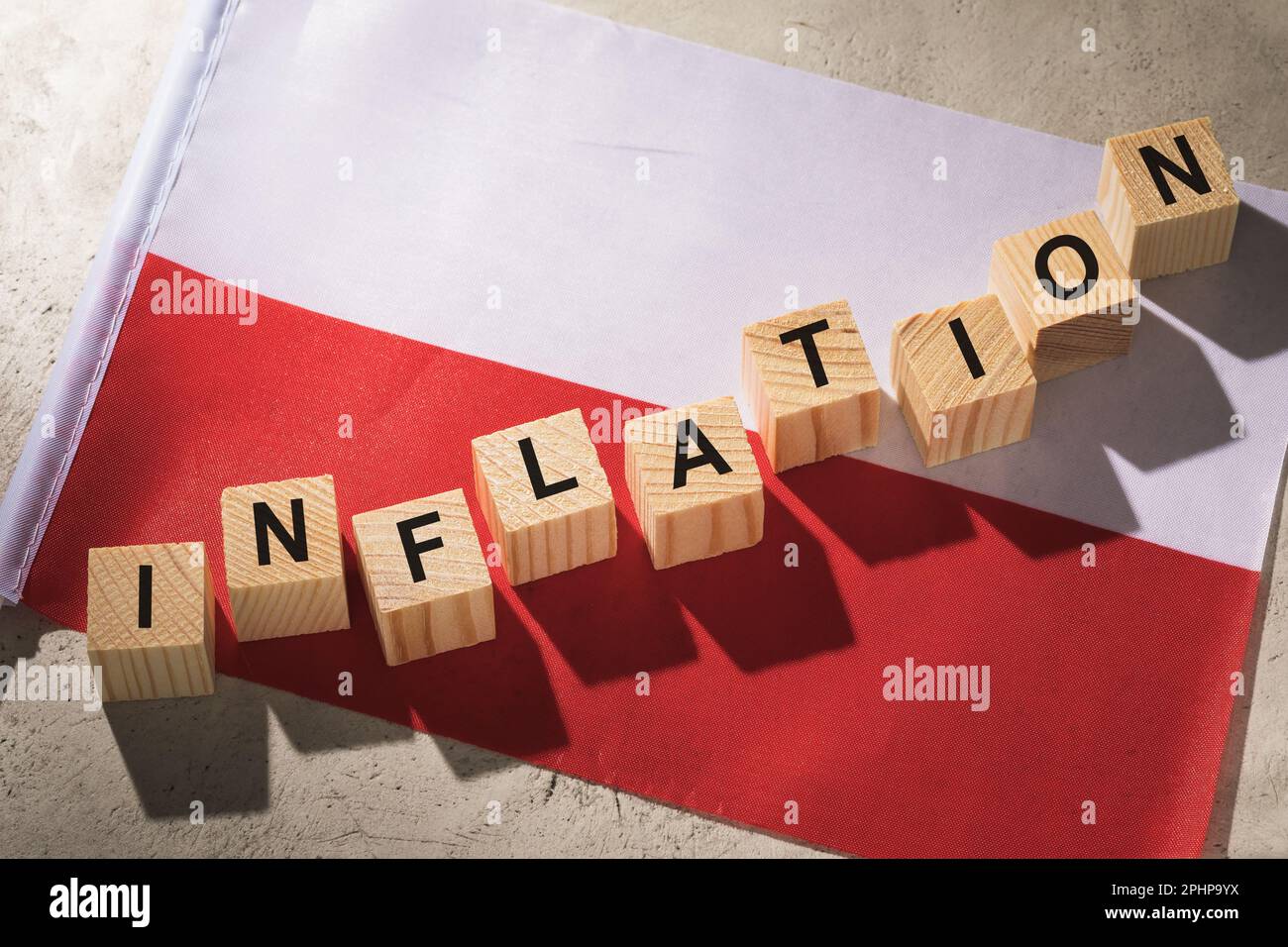 Polnische Flagge und Holzwürfel mit Text, ein Konzept zum Thema Inflation im Land Stockfoto
