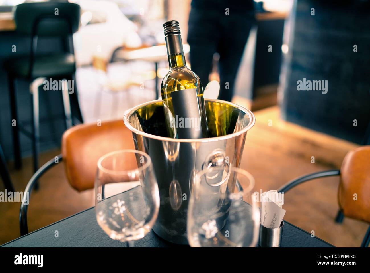 Eine Flasche Wein im Eiskübel auf dem Restaurant- oder Bartisch. Getränkekühler im Pub. White sauvignon Blanc, chardonnay oder riesling. Stockfoto
