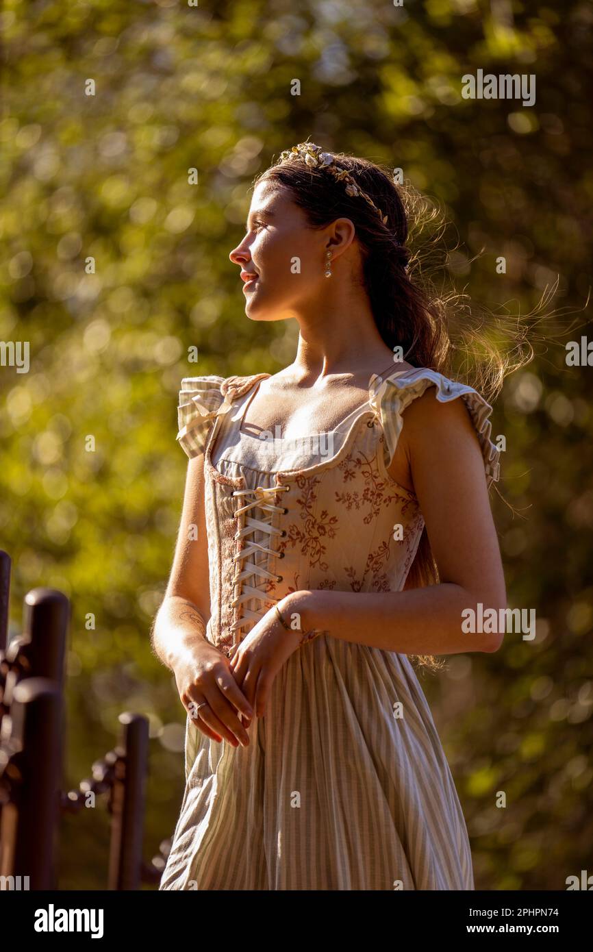 Beautiful Young Woman Stehend With Arms at Side in Profile | up Angle | Outdoors | Storybook Prinzessinnen Korsett Stockfoto