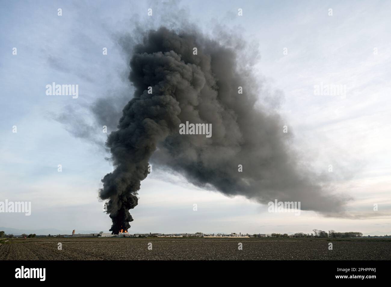 Die chemische Lösungsmittelanlage brennt mit einer schwarzen Säule giftigen Rauchs nieder. Novara, Italien - März 2023 Stockfoto