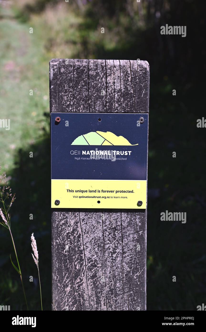 Schild mit der Aufschrift QE11National Trust Covenanted Land entlang der Queen Charlotte Track in den Marlborough Sounds, South Island, Neuseeland. Stockfoto