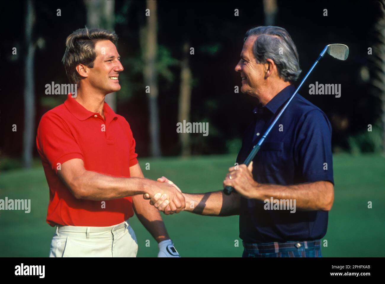 1990 HISTORISCHE MÄNNER SCHÜTTELN SICH DIE HÄNDE AUF DEM SÜDLICHEN GOLFPLATZ DER USA Stockfoto