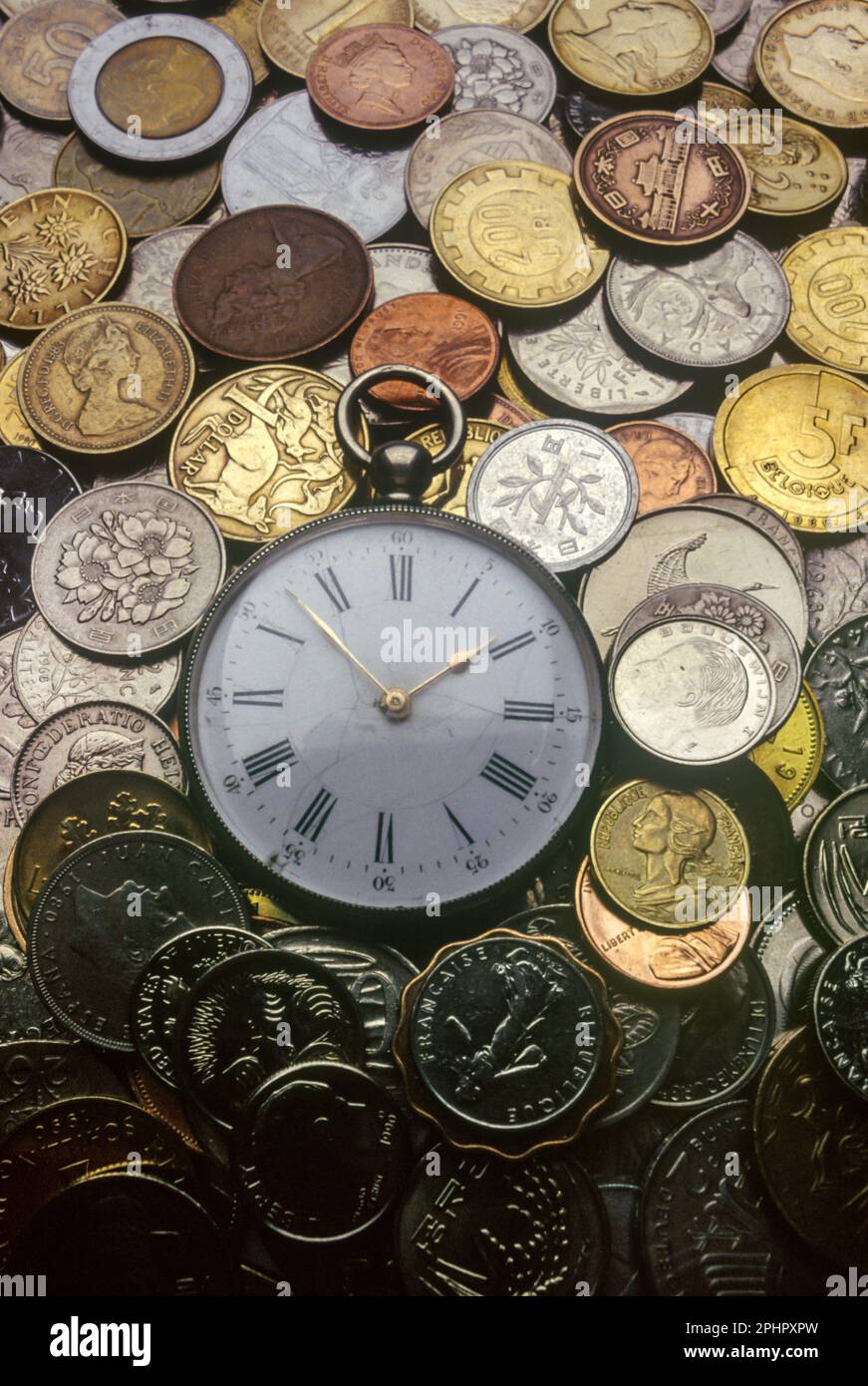 ALTE NATIONALMÜNZEN UND ALTMODISCHE TASCHENUHR Stockfoto