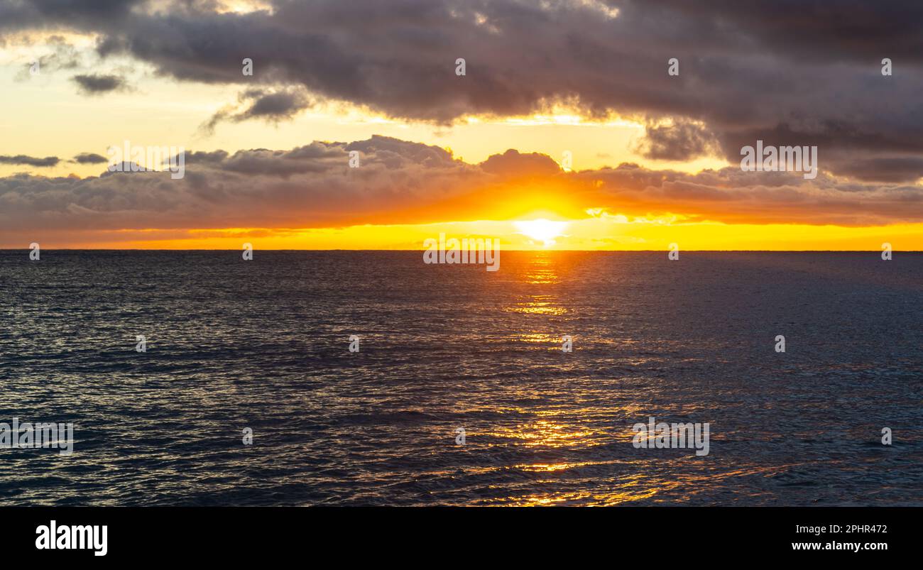 Sonnenaufgang am Meer, Morgenmeer, dramatischer Sonnenuntergang in den Wolken, Orange Horizon in der goldenen Stunde, wunderschönes Urlaubskonzept für Sonnenaufgang am Meer Stockfoto
