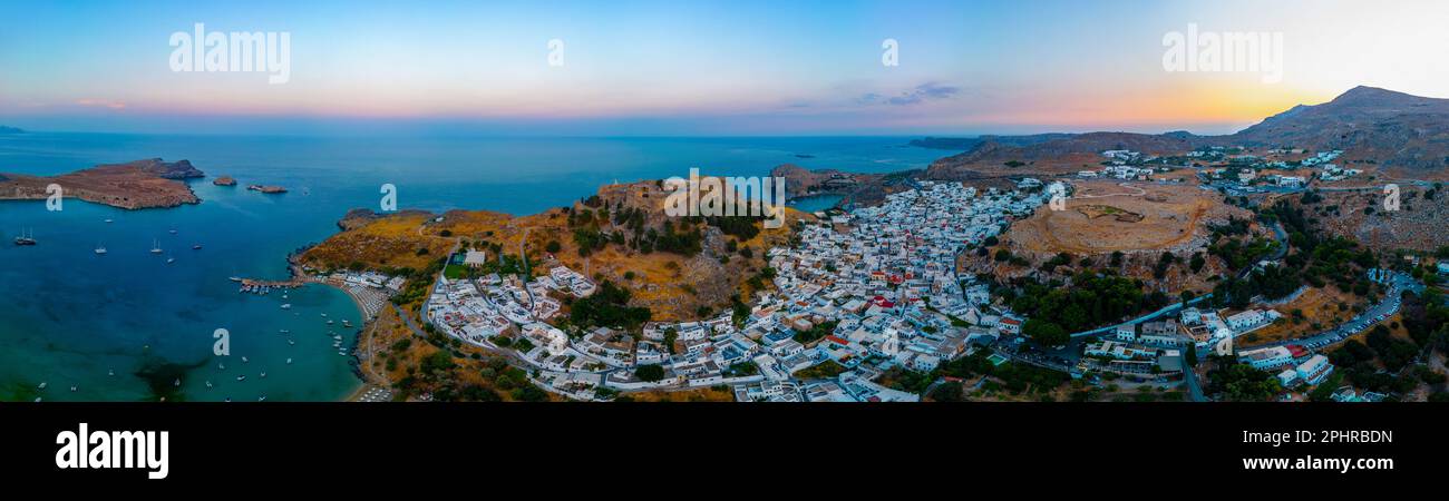 Blick auf die Akropolis von Lindos bei Sonnenuntergang mit Blick auf traditionelle weiße Häuser auf der Insel Rhodos, Griechenland. Stockfoto
