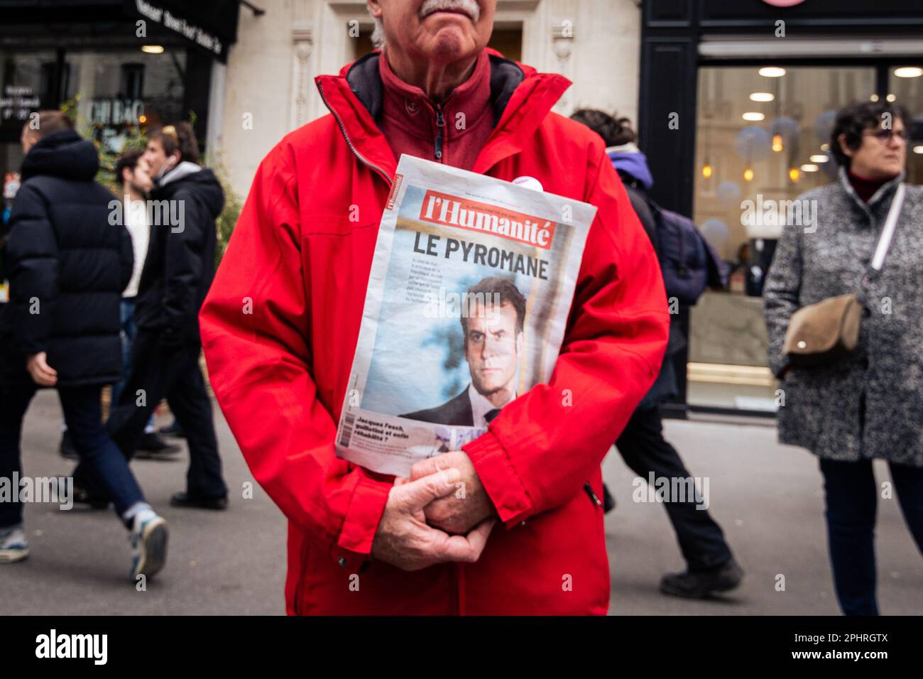 Paris, Frankreich. 28. März 2023. Ein Protestteilnehmer sah während der Kundgebung gegen die Rentenreform eine Zeitung mit dem Titel "Le Pyromane" und Macrons Porträt in der Hand. Die zehnte Rallye gegen die Rentenreform brachte Tausende auf die Straßen von Paris, an einem weiteren Tag, der von gewaltsamen Zusammenstößen zwischen Polizei und Demonstranten geprägt war. Macrons unbeliebtes Rentengesetz erzeugt weiterhin eine Welle von Protesten und Streiks in ganz Frankreich. (Foto: Telmo Pinto/SOPA Images/Sipa USA) Guthaben: SIPA USA/Alamy Live News Stockfoto