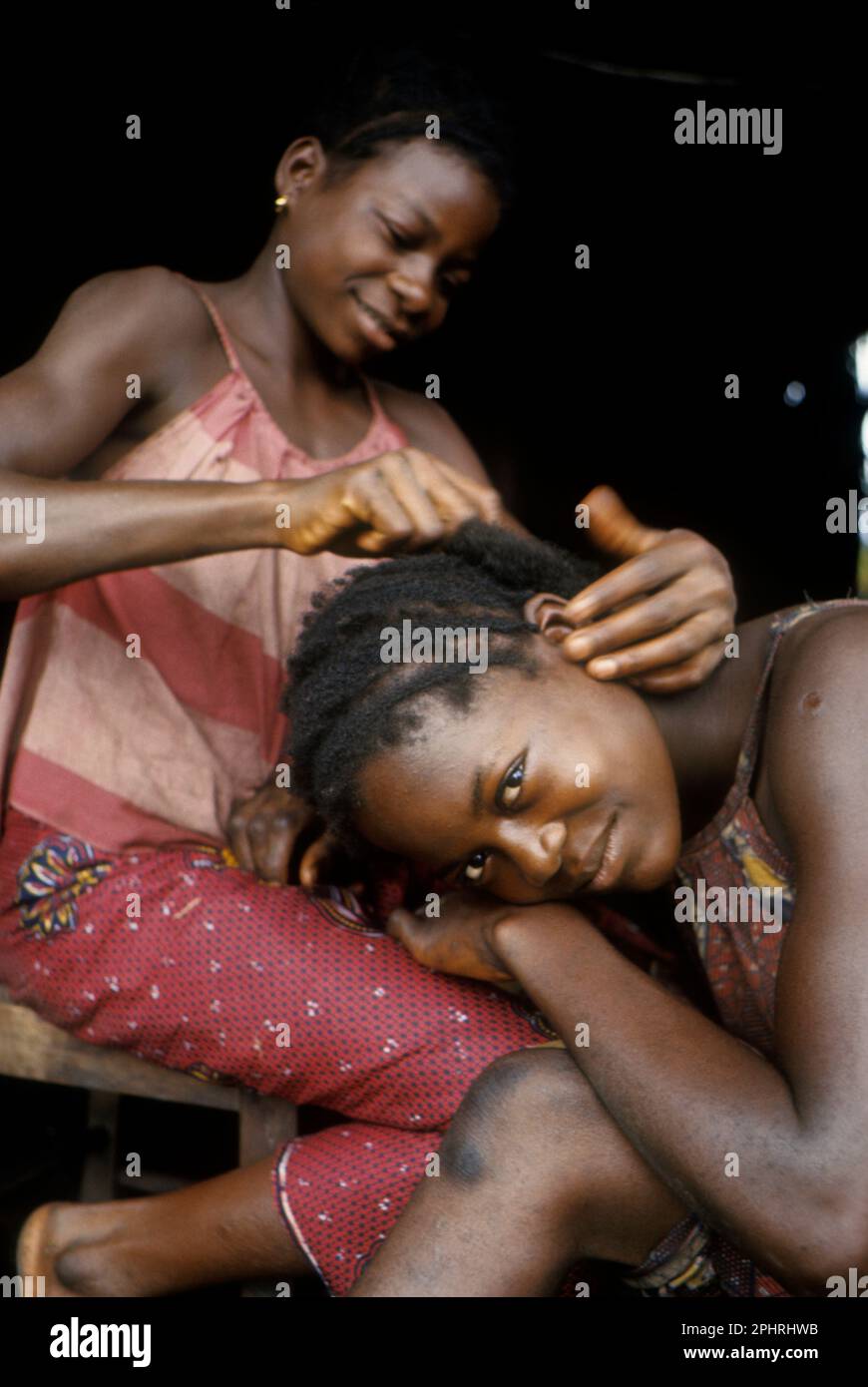 Afrika, Demokratische Republik Kongo, Ngiri-Gebiet, ethnische Gruppe der Libinza. Ein Mädchen, das die Haare eines anderen Mädchens pflegt. Stockfoto