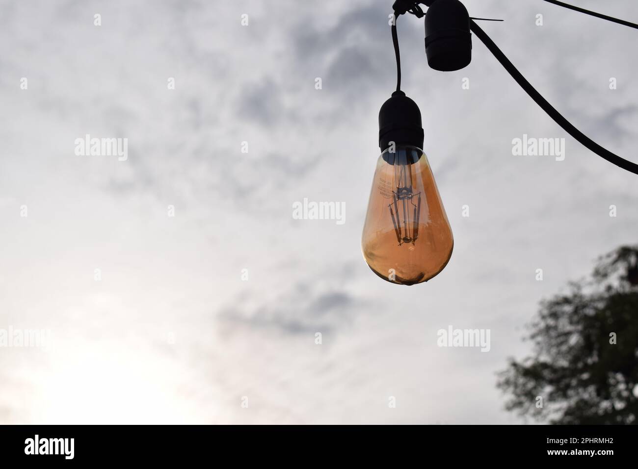 Elektrisches Licht am blauen Himmel bei sonnigem Wetter. Lampe für die Gartenbeleuchtung zu Hause. Stockfoto