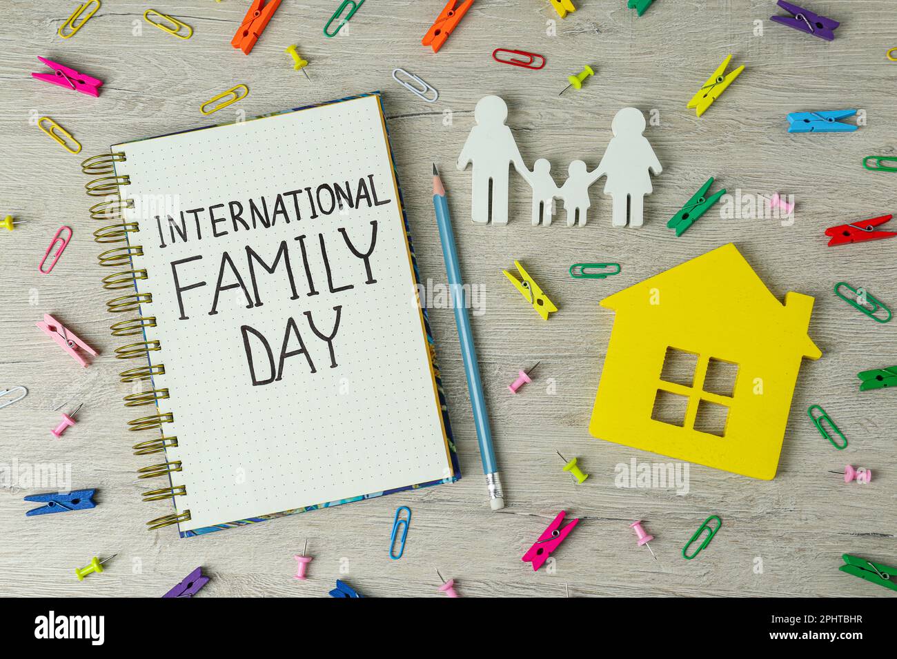 Alles Gute Zum Familientag. Flache Liegezusammensetzung mit Notizbuch, Figuren und Schreibwaren auf Holztisch Stockfoto