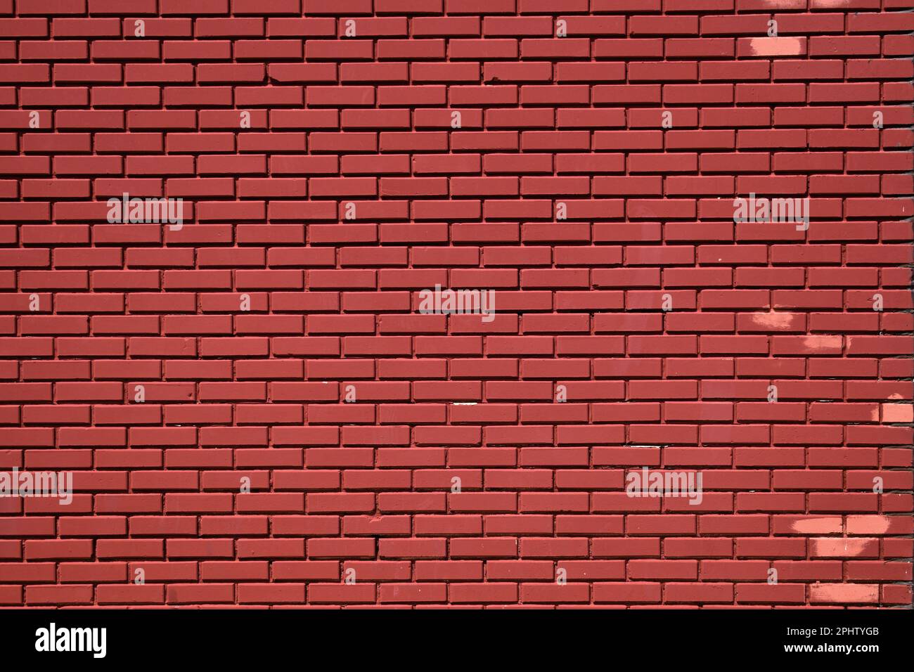 Rosafarbene Flecken an der Wand aus rosa Ziegelsteinen Stockfoto