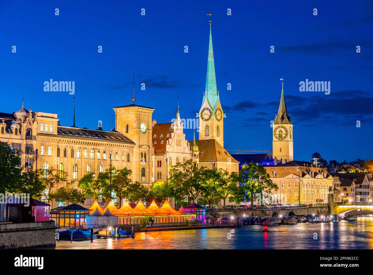 Blick auf den Sonnenuntergang über das historische Stadtzentrum von Zürich mit der berühmten Fraumünsterkirche und dem Fluss Limmat an einem sonnigen Tag in der Schweiz. Stockfoto