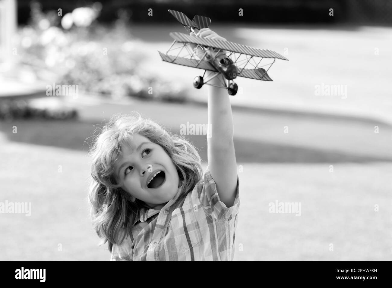 Porträt eines Kindes mit Spielzeugpapierflügeln im Freien. Erfolg, Kreativität und Startkapital. Stockfoto