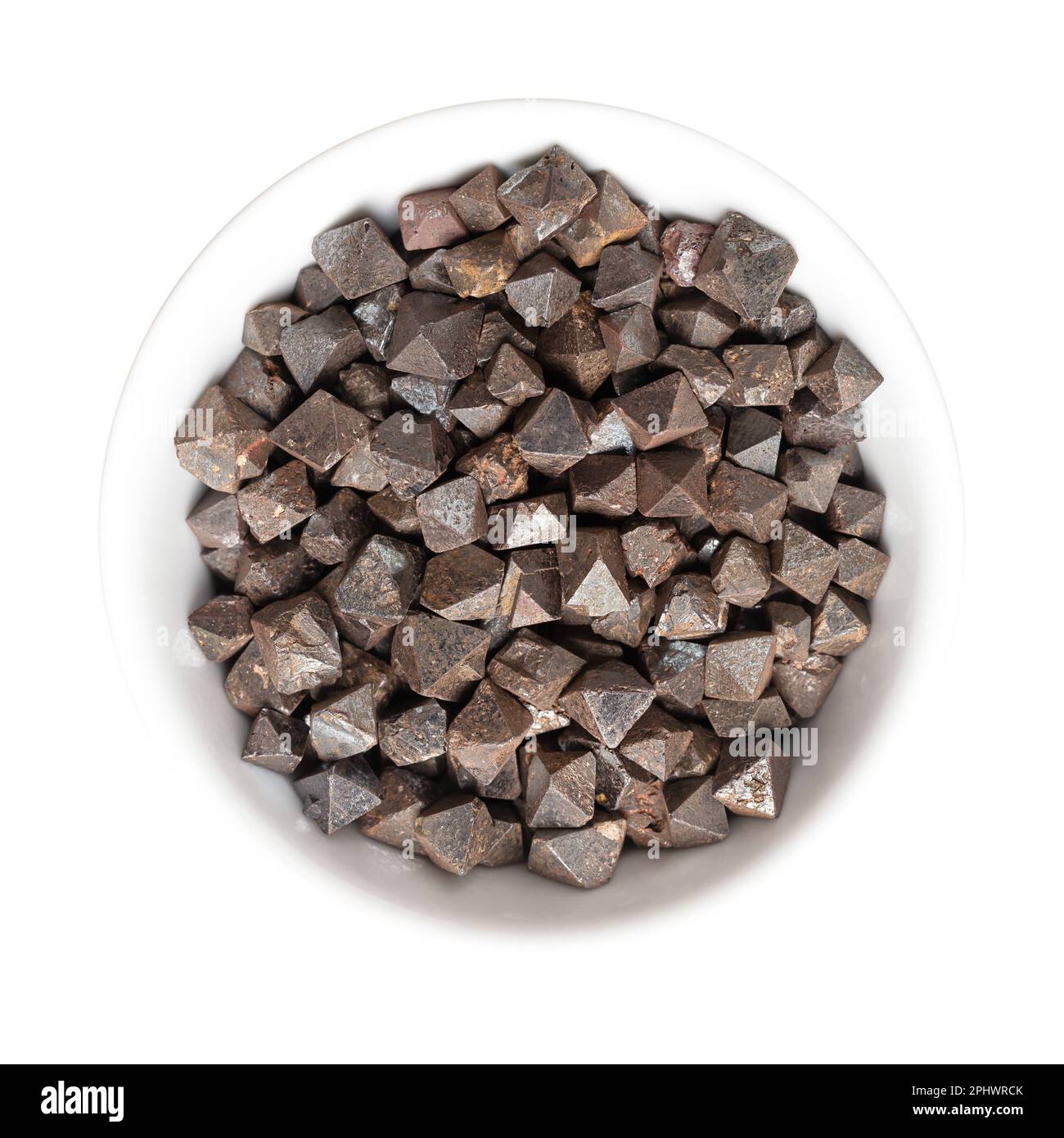 Magnetitkristalle in einer weißen Schüssel. Eisen(II,III)-oxid, achtahedral, Doppelpyramide und platonisch massiv. Die magnetischsten aller vorkommenden Mineralien. Stockfoto