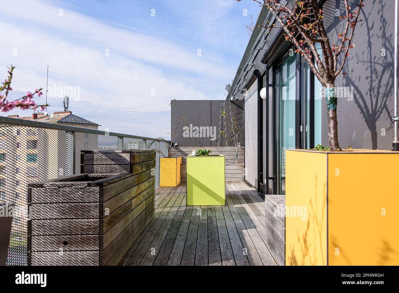 Farbenfrohe Dachterrasse in Wien mit gelben und grünen Möbeln für städtische Gartenarbeit Stockfoto