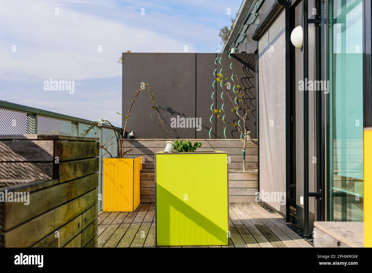 Farbenfrohe Dachterrasse in Wien mit gelben und grünen Möbeln für städtische Gartenarbeit Stockfoto