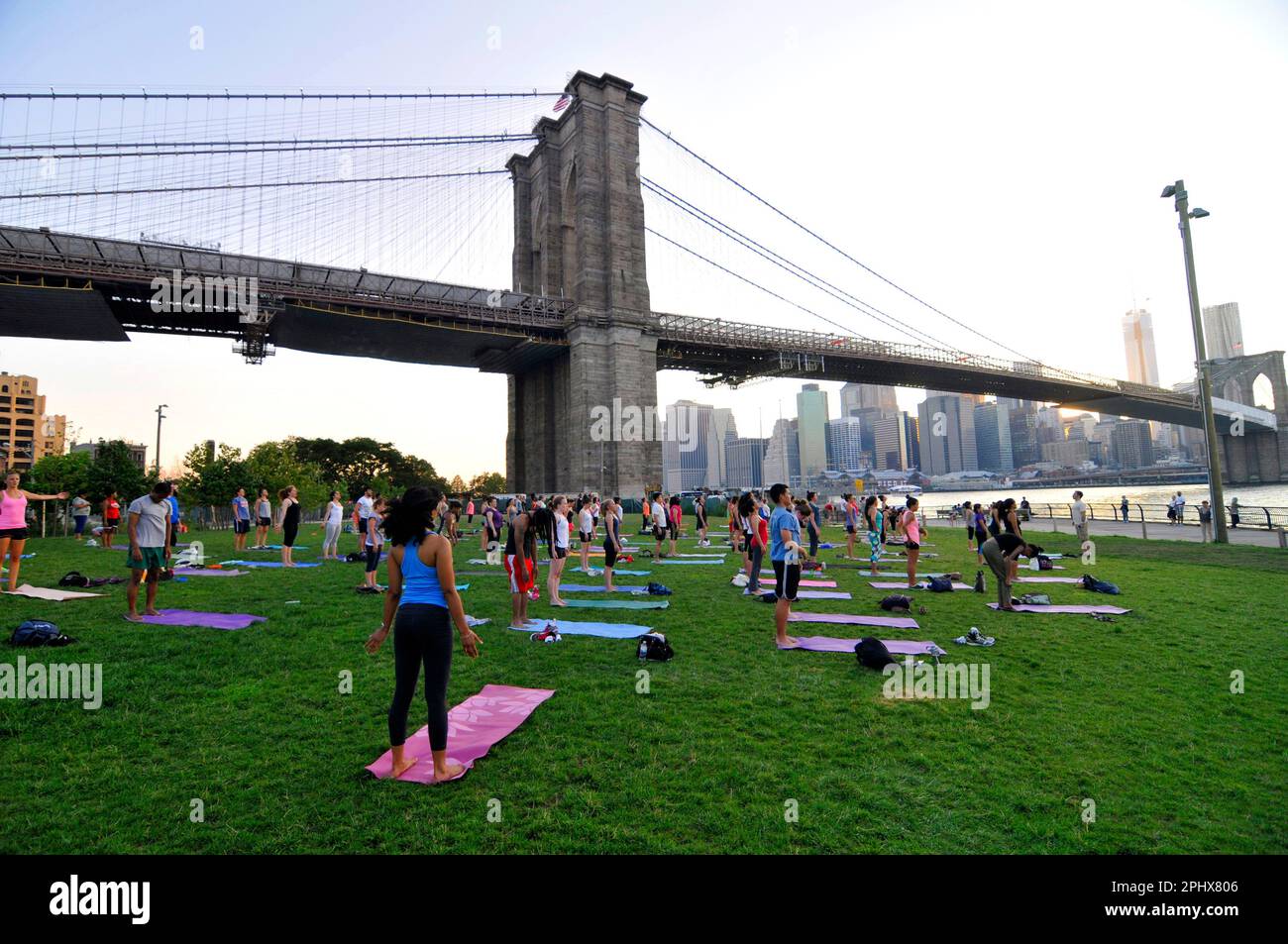 Yoga-Session bei Sonnenuntergang im Brooklyn Bridge Park in New York City, NY, USA. Stockfoto