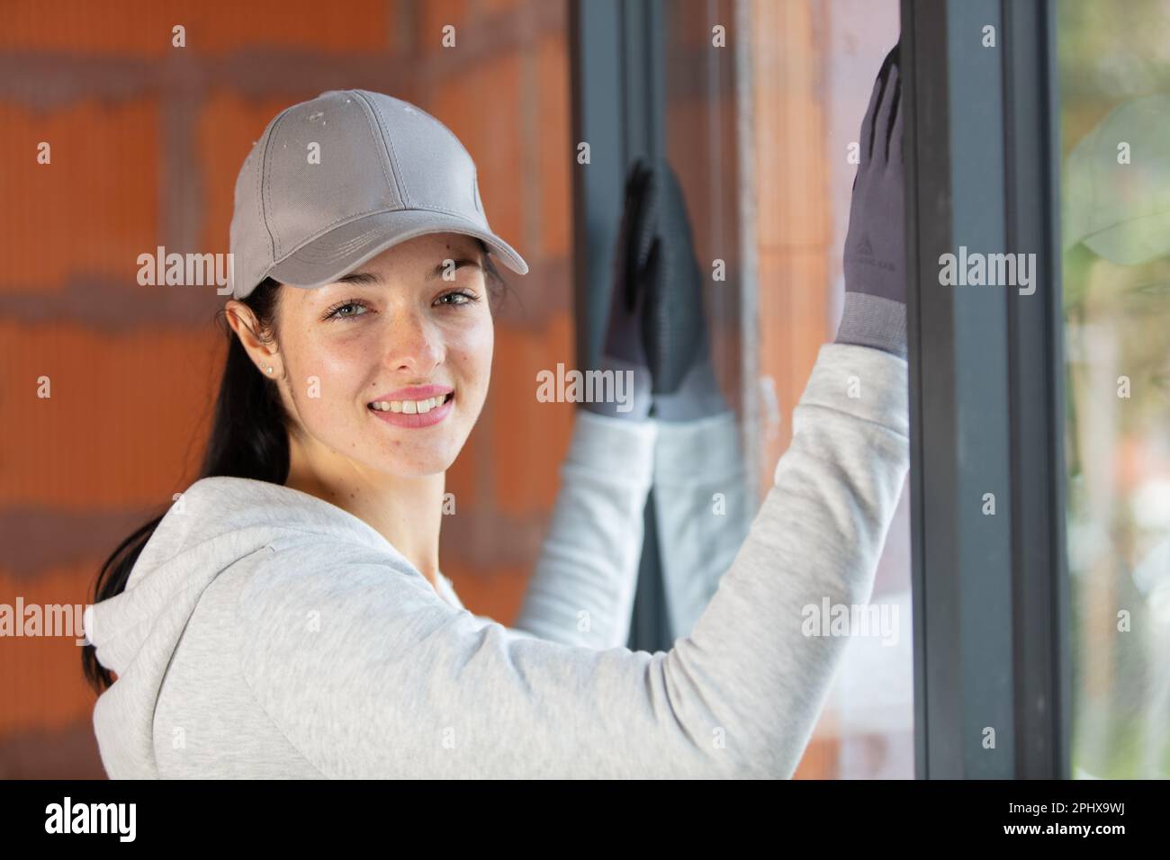 Porträt einer jungen Fenstermontiererin Stockfoto
