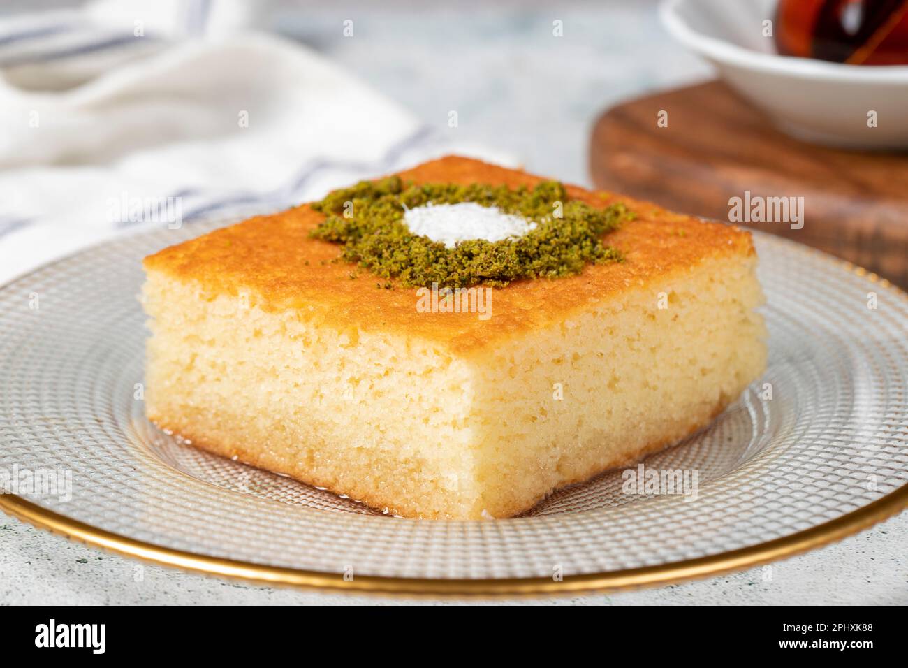 Revani Nachtisch. Süßer Grießkuchen mit Pistazien. Ramadan-Süßigkeiten. Traditionelle türkische Köstlichkeiten. Revani-Dessert mit Sirup auf einem grauen Backgr Stockfoto