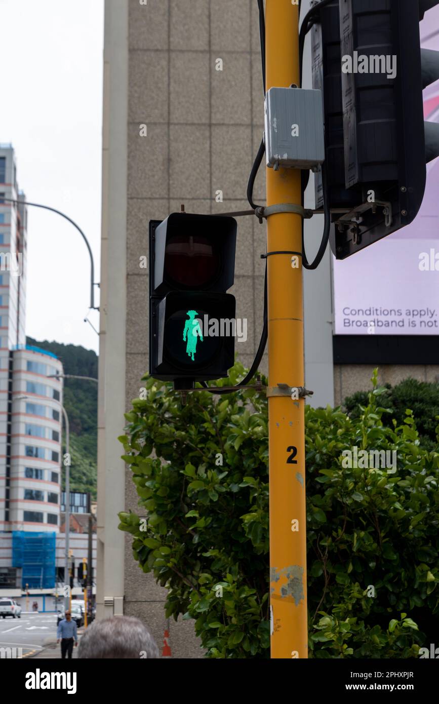 Fußgänger überquert grünes Licht mit altbekleideten weiblichen Umrissen in Wellington, Neuseeland. Stockfoto